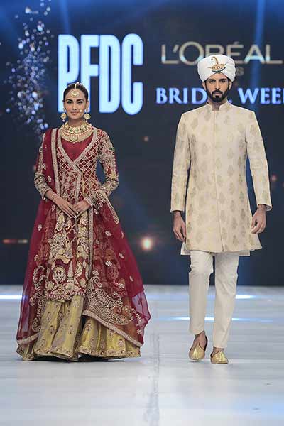 Bridal in traditional red and golden short shirt with golden lehnga and red dupatta and groom in cream sherwani with turban and trouser latest indian and pakistani wedding matching dress combinations for bride and groom 2017