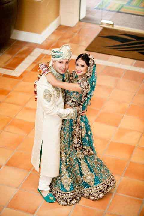 Bride in zink green lehnga choli with dupatta and groom in white sherwani with matching zink green turban latest indian and pakistani wedding matching dress combinations for bride and groom 2017